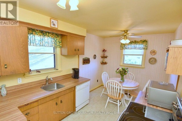 Kitchen with wood cabinets, dining table, and appliances - 499 Valley Drive N Oakville