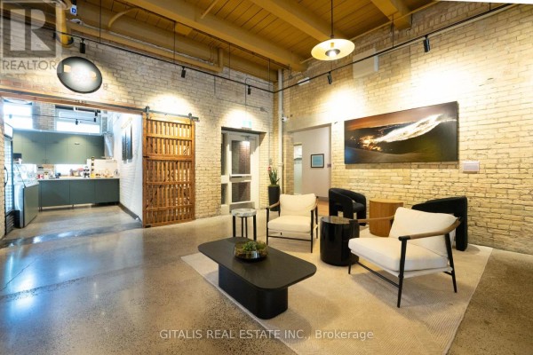 Gym interior with treadmills, stationary bikes, and yellow accent wall with artwork. - 4a - 219 Dufferin Street, Toronto