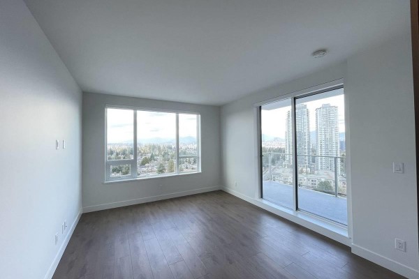 Bedroom with large windows offering city and mountain views, and sliding glass door to balcony. - 4xx 13359 Old Yale Rd, Surrey