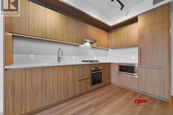 Corner kitchen with wood cabinets, stainless steel appliances, and grey countertop. - 4xx 5987 Wilson Avenue, Burnaby