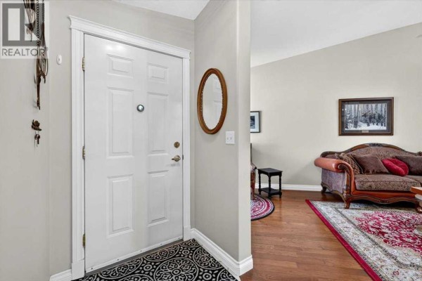 Interior view of a white double front door with a decorative oval mirror and a patterned rug. - 5, 1200 Milt Ford Lane, Carstairs