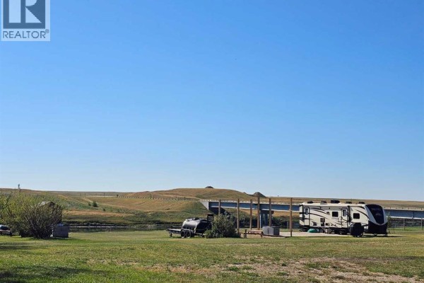Open land with RV parked, blue sky, and rolling hills in the background. - 5, 172039 Hwy 539, Bow City