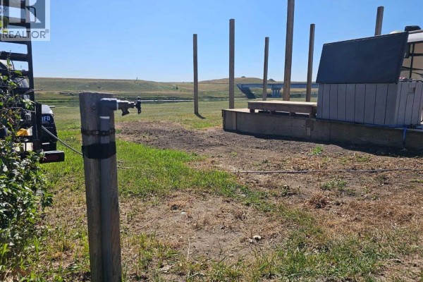Water spigot on a grassy area near RV and wooden posts. - 5, 172039 Hwy 539, Bow City