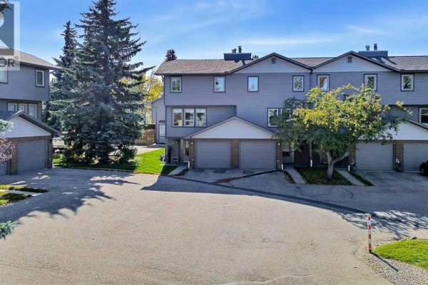 Aerial view of a townhouse complex with grey exteriors and mature trees. - 5, 64 Woodacres Crescent Sw, Calgary