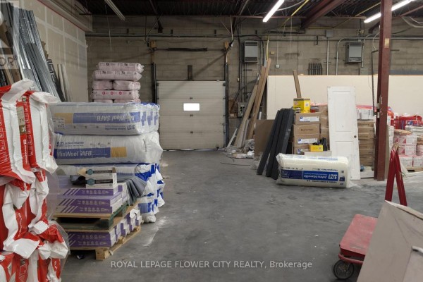 Storage area with stacked insulation, building materials, and a roll-up door in the background. - 5,6 - 1201 Franklin Boulevard, Cambridge