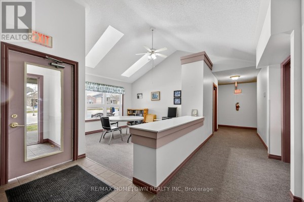 Interior hallway and common room with vaulted ceiling and exit signs. - 5 - 1171 Millwood Avenue, Brockville