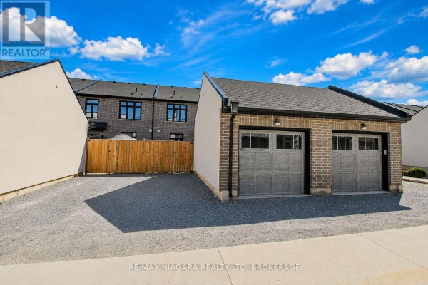Exterior view of a detached double-car garage with brick facade and asphalt driveway. - 153 Summersides Boulevard, Pelham