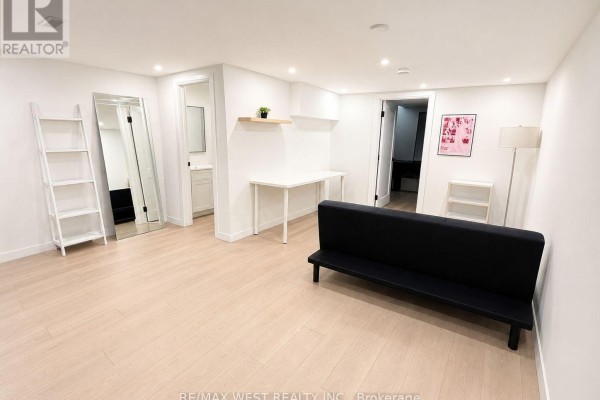 Spacious basement room with a full-size mirror, ladder shelf, and two seating areas. - 5 - 202 Perth Avenue, Toronto