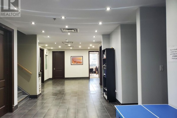 Interior hallway with tiled floors, dark wood doors, and recessed lighting. A staircase is visible on the left. - 5 - 204 - 15 Brownridge Road, Halton Hills