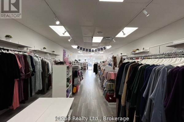 Hallway in a commercial space with closed doors, shelves, and a table with a box. - 5 - 2645 Liruma Road, Mississauga