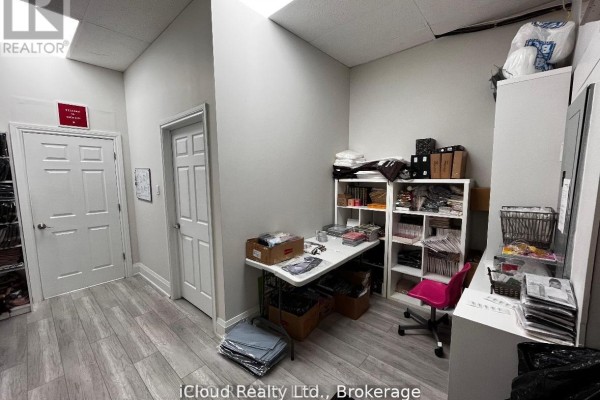Wide view of a brightly lit retail store with clothing displayed on racks on both sides. - 5 - 2645 Liruma Road, Mississauga