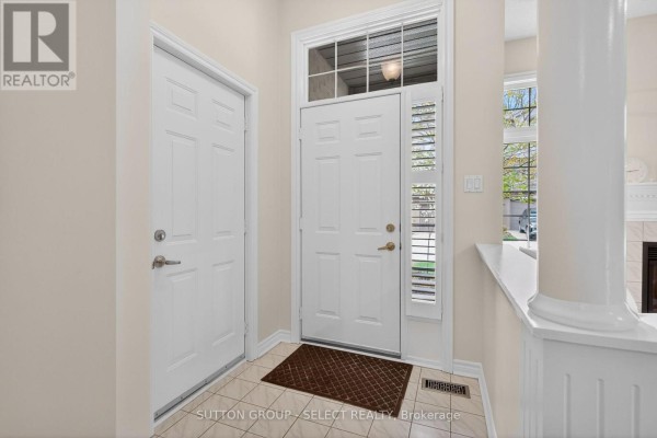 Interior entryway with two white doors, a white pillar, and a large front door with a window. - 5 - 270 North Centre Road, London North
