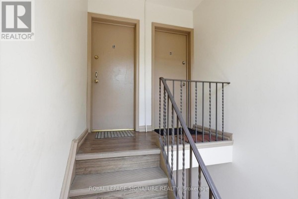 Interior hallway with two doors, stairs, and railing. - 5 - 46 Albert Avenue, Toronto