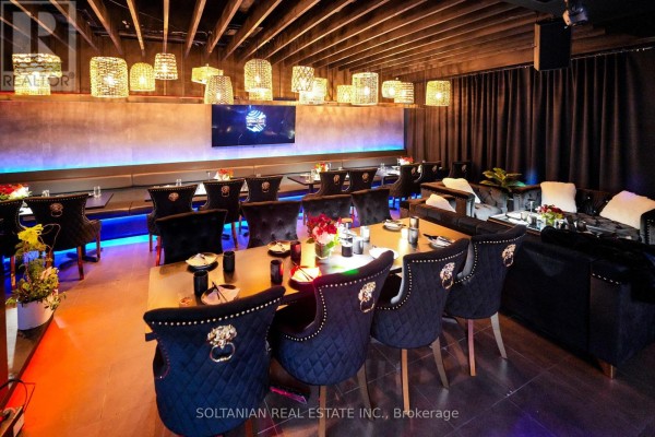 Restaurant dining room with dark upholstered chairs, large tables, and decorative pendant lights. - 5 - 5 Glen Cameron Road, Markham