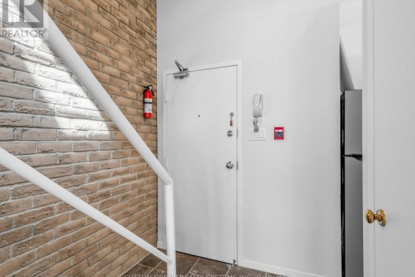 Close-up of the main entrance at 6 Bartlett Avenue with grey stone facade and glass double doors. - 5 - 6 Bartlett Avenue W, Toronto