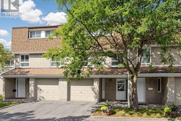 Front exterior of a townhouse showing garages, doors, and brick facade under a large tree. - 5 - 77 Rameau Drive, Toronto