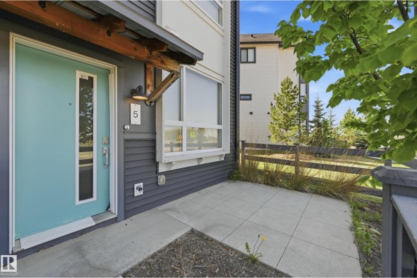 View from a townhouse patio looking at a street with a car and buildings. - #5 100 Jensen Lakes Bv, St  Albert