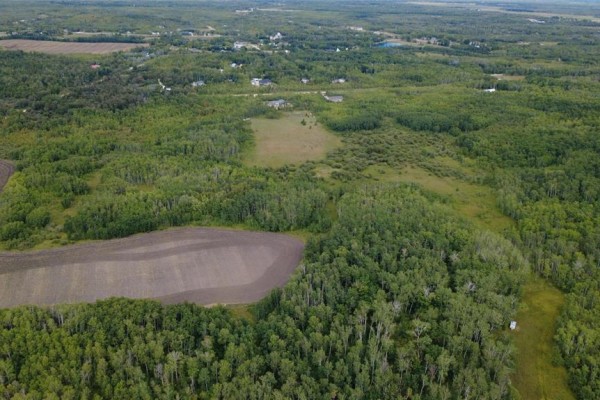 Aerial view of wooded land and fields with some houses in the distance. - 5 44 N Road, Ste Anne Rm