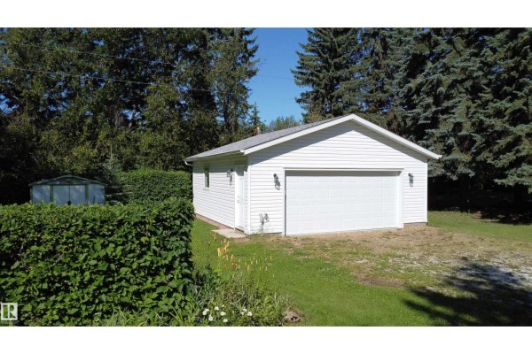 White detached garage with a large white door, outdoor lights, and manicured hedges. - #5 54015 Rge Road 262, Rural Sturgeon County