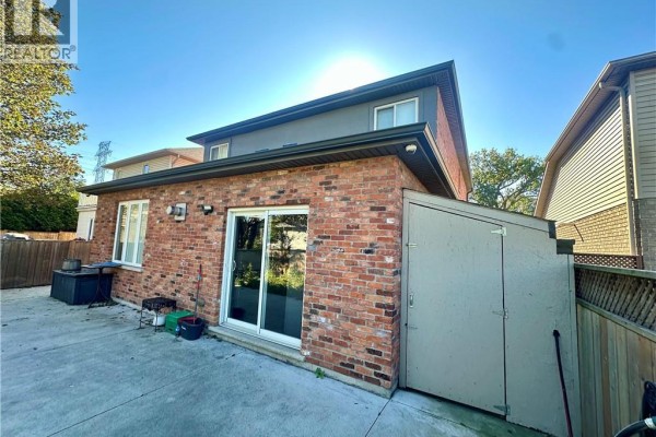 Front view of a two-story brick house with a garage door, balcony, and small front yard. - 5 Arden Avenue, Hamilton