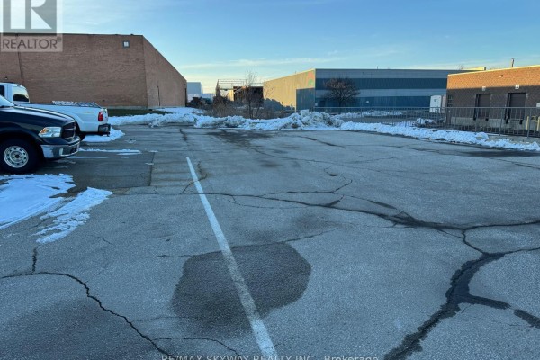 Paved parking lot with snow, vehicles parked, and industrial buildings in background - 5 Automatic Road, Brampton