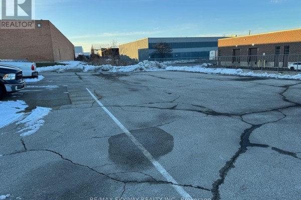 Paved parking lot showing snow patches, vehicles, and surrounding industrial area - 5 Automatic Road, Brampton