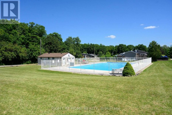 Outdoor swimming pool with lounge chairs and picnic tables in a grassy area. - 5 Beech Street - 4449 Milburough Line, Burlington