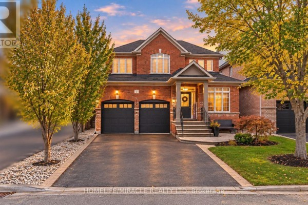Wide exterior view of a red brick house with a double garage and manicured lawn in autumn. - 5 Billancourt Crescent, Brampton