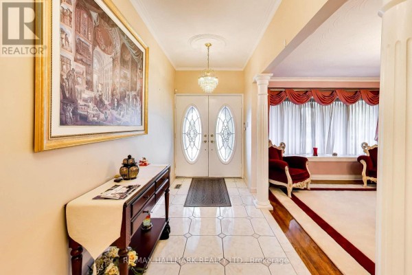 Interior foyer with double doors, tiled floor, console table, and large framed artwork. - 5 Byworth Boulevard, Toronto
