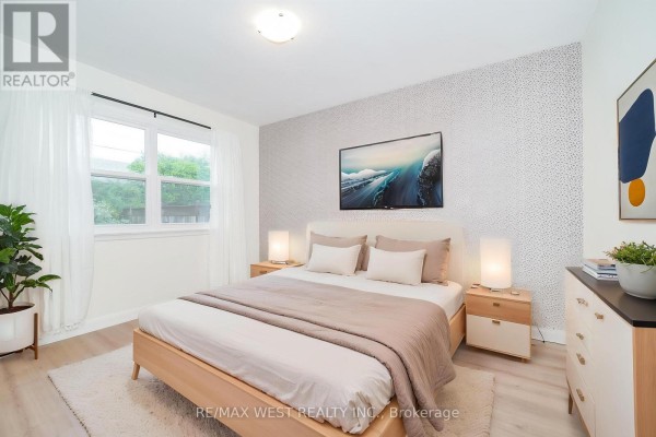 Bedroom with a king-size bed, a textured wallpaper accent wall, and bedside tables. - 5 Cromarty Drive, Toronto