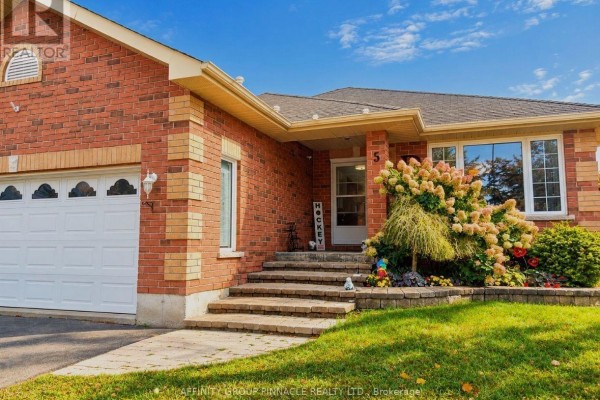 Close-up of the entrance to a brick bungalow with stone steps and landscaping. - 5 Denfield Road, Kawartha Lakes