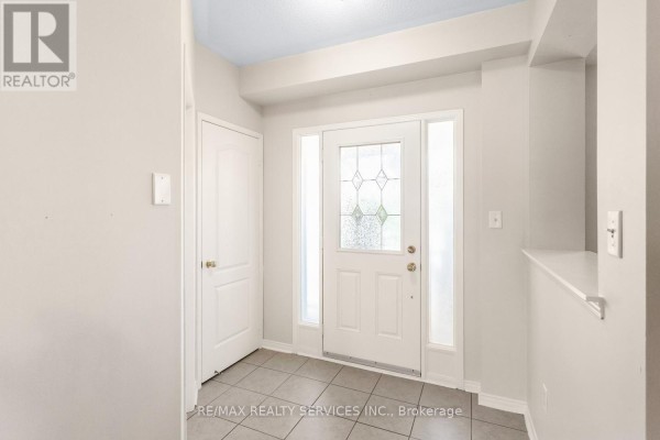 Interior foyer with tiled floor, white walls, a white door, and a glass-paneled front door. - 5 Dollery Gate, Ajax