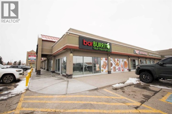 Commercial kitchen counter with POS systems, paper bags, and stainless steel appliances. - 5 Falsbridge Drive Ne, Calgary