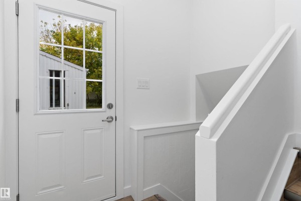 Close-up of a white door with glass panes, reflecting an outdoor structure and trees. - 5 Glenbrook Bv, Sherwood Park