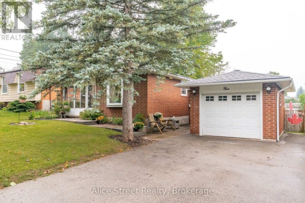 Close-up of the white garage door on the red brick bungalow with a paved driveway. - 5 Glenbrook Drive, Guelph