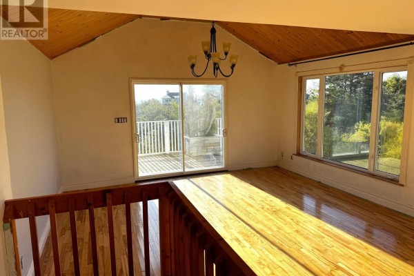 Room with hardwood floors, wooden ceiling, sliding glass doors to a deck, and large windows. - 5 Homestead Road, Bayswater