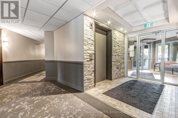 Apartment building lobby with elevator, stone accent wall, and glass doors. - 5 Jacksway Crescent, London North