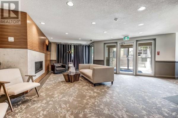 Building common area with fireplace, seating, wood accent wall, and glass doors. - 5 Jacksway Crescent, London North