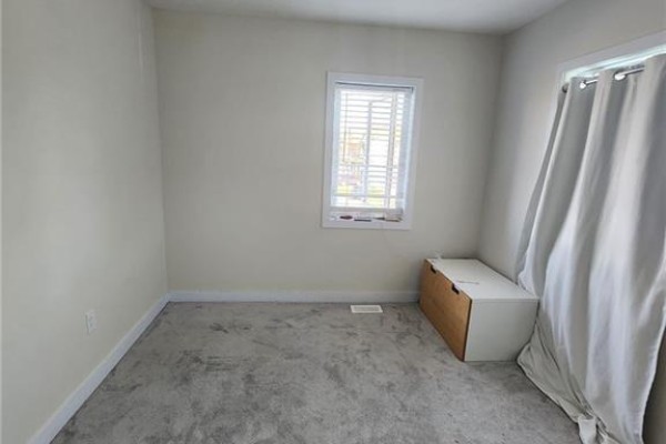 Bedroom with beige walls, grey carpet, a white storage bench, and a window with blinds. - 5 Keelson Street, Welland
