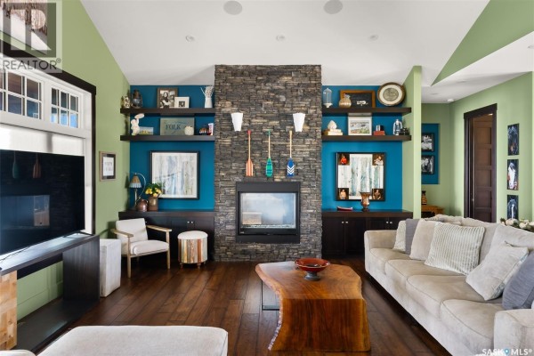 Living room with a stone fireplace, built-in shelves, and a mix of blue and green accents. - 5 Kiiswa Point, Mckillop Rm No  220