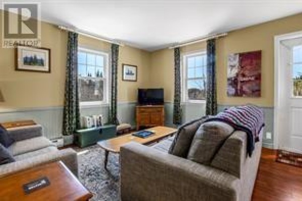 Living room with two couches, coffee table, and two windows with curtains. - 5 Marshall’s Hill, Trinity East