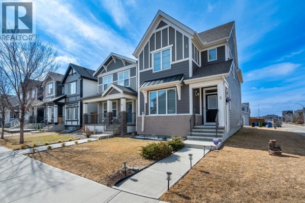Front exterior of a modern two-story house with gray siding, white trim, and a dark front door, angled view. - 5 Masters Street Se, Calgary