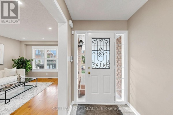 Foyer with a white front door, sidelight windows, and a view into the living area. - 5 Mendoza Drive, Brampton