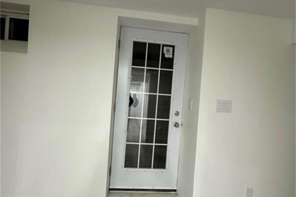 A white door with glass panes and a grid pattern, leading into a room with white walls. - 5 Munro Circle Unit# Lower, Brantford
