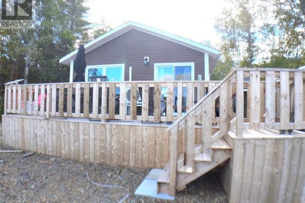 Large wooden deck wraps around the back of the house with stairs leading down. - 5 Old Road, Western Arm Other, Point Leamington