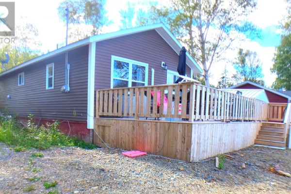 View of the house's back deck and side exterior from the yard. - 5 Old Road, Western Arm Other, Point Leamington
