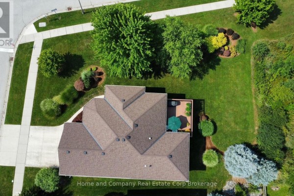 Aerial view of a house roof and backyard with a deck, lawn, and mature trees. - 5 Ridgewood Crescent, St  Marys