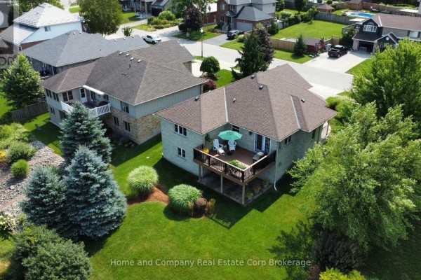 Aerial view showing the rear of the house with a wooden deck, green lawn, and mature trees. - 5 Ridgewood Crescent, St  Marys