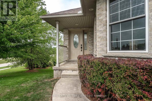 Front entrance of a brick house with a covered porch, glass-paneled door, and manicured bushes. - 5 Ridgewood Crescent, St  Marys