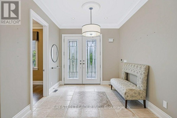 Interior entryway with beige walls, tiled floor, and double glass doors. - 5 River Stone Court, East Gwillimbury